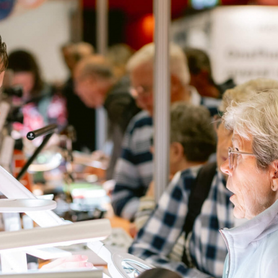 Foto van beursbezoekers in gesprek met een standhouder