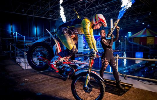 Stuntrijder op voorwiel met vuuracts in Fire Arena