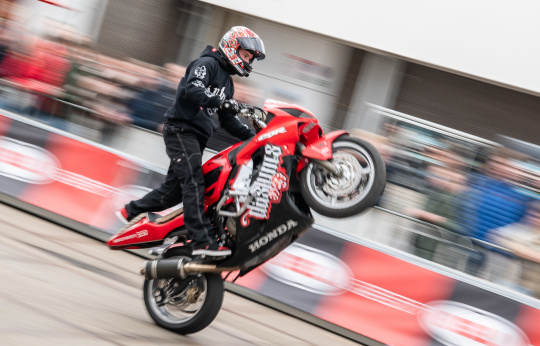 Stuntrijder rijdt op achterwiel op motorfiets in Stunt Arena